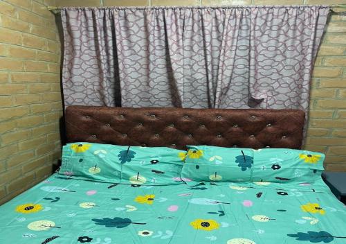 a bed with a blue comforter and two pillows at SJ Kololi Apartments Senegambia Area in Sere Kunda