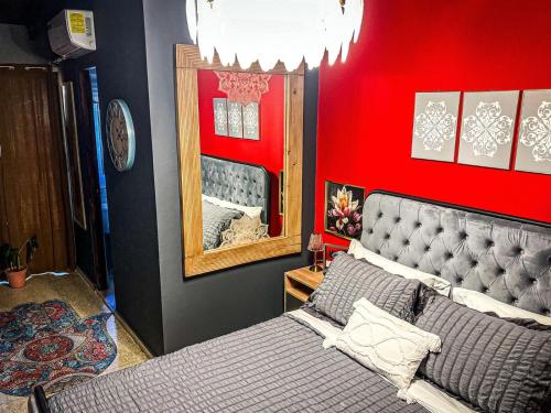a bedroom with a bed and a red wall at ORHO Hotel Boutique 15 minuts PTY Airport free shuttle in Tocumen