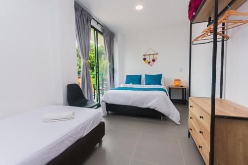 a bedroom with two beds and a dresser at Guatapé Country House Hotel in Guatapé