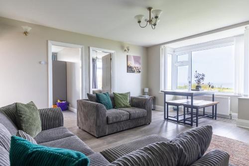 a living room with two couches and a table at BEACHFRONT APARTMENT - Ground Floor Apartment with Sea Views, Next to the Beach, Bridlington, North Yorkshire in Bessingby