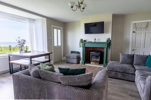 a living room with two couches and a fireplace at BEACHFRONT APARTMENT - Ground Floor Apartment with Sea Views, Next to the Beach, Bridlington, North Yorkshire in Bessingby