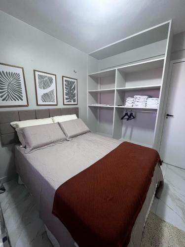 a bedroom with a large bed and shelves at Marino Beach in Aquiraz