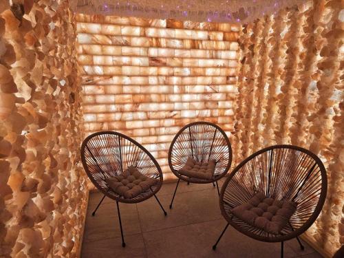 three chairs sitting in front of a brick wall at Słoneczny Brzeg - Apartamenty w Pieninach in Krościenko