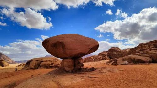 a large rock sitting on top of a desert at Lowrance luxury camp in Wadi Rum