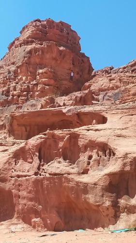 a rock formation in the desert with a cliff at Lowrance luxury camp in Wadi Rum