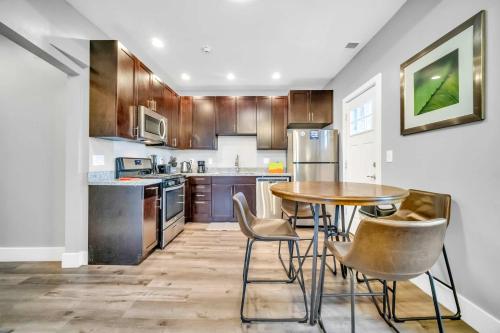 a kitchen with wooden cabinets and a table and chairs at Cle Suites 1BR 1BA 5 min Walk to Cle Clinic #10 in Cleveland
