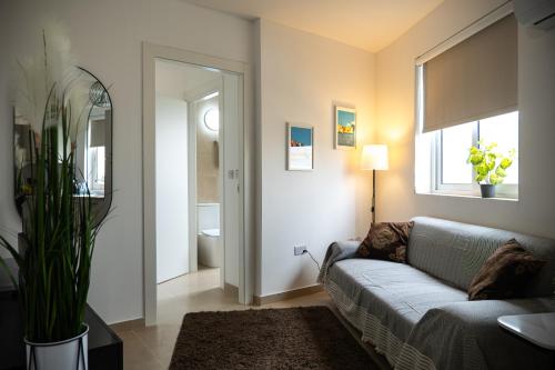 a living room with a couch and a window at Stella & Rosie - Two Bedroom Apartment's by ELDI in Pieta