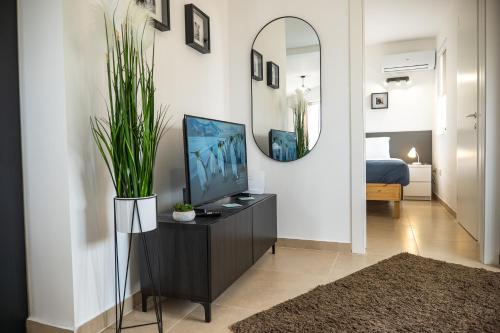 a living room with a television and a mirror at Stella & Rosie - Two Bedroom Apartment's by ELDI in Pieta
