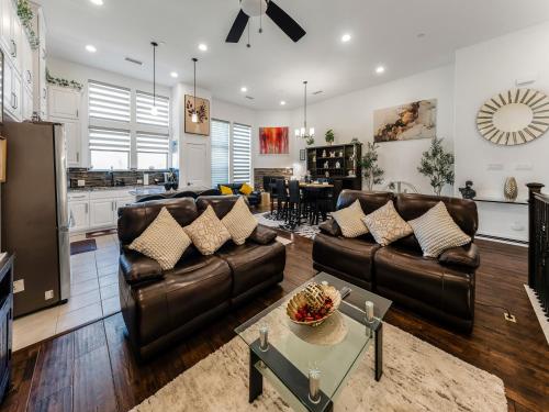 a living room with leather furniture and a kitchen at A Homely Getaway in Lewisville
