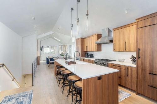 a kitchen with wooden cabinets and a kitchen island with bar stools at Upscale Condo Near Lift and Town with Mountain Views in Telluride