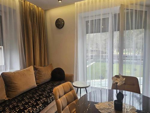 a living room with a couch and a glass table at Słoneczny Brzeg - Apartamenty w Pieninach in Krościenko