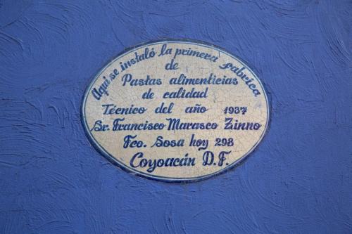 a plaque on a blue wall with a writing on it at Mar de Lava in Mexico City