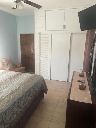 a bedroom with a bed and a dresser and a tv at Le Quad - One Bedroom & Studio Apt - Private, Spacious & Secured in Kingston