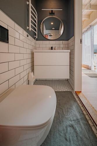 a bathroom with a white toilet and a mirror at Svencelė K-17 in Svencelė