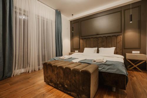 a bedroom with a large bed with a wooden headboard at Darki Comfort Apartments - Stylish and Comfortable Apartments with Free Parking in Ohrid