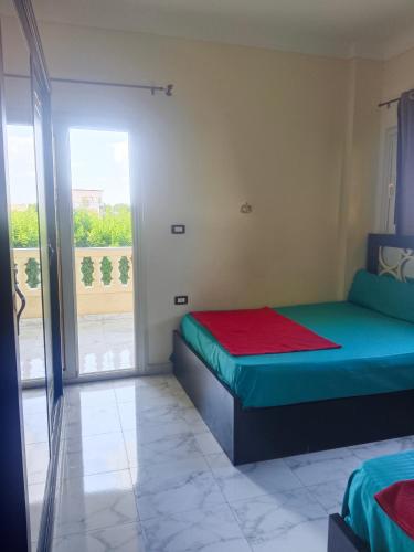 a bedroom with two beds and a balcony at Villa Ahmed Youssef king marrouit in King Mariout