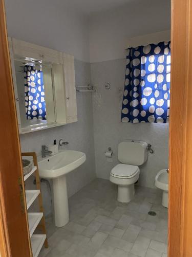a bathroom with a white toilet and a sink at Ionian Escape in Ayia Evfimia