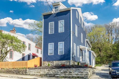 a blue house on the side of a street at Spacious & Cozy Central Cincinnati Home in Cincinnati