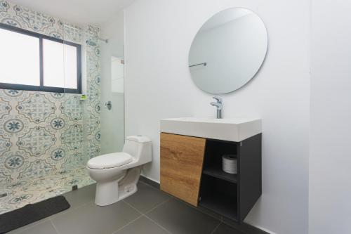 a bathroom with a white toilet and a mirror at Guatapé Country House Hotel in Guatapé