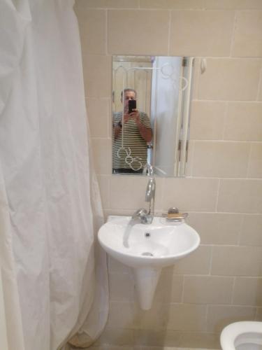 a man taking a picture of a sink in a bathroom at Luxor Egipto in Luxor