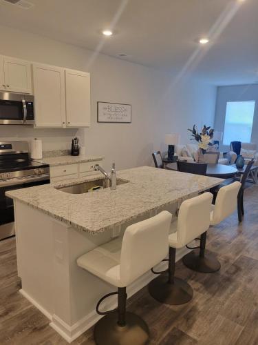 a kitchen with a sink and a counter with chairs at Coastal Charm 3-bedroom townhome in Myrtle Beach