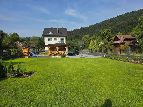 a large yard with a house and a playground at Słoneczny Brzeg - Apartamenty w Pieninach in Krościenko