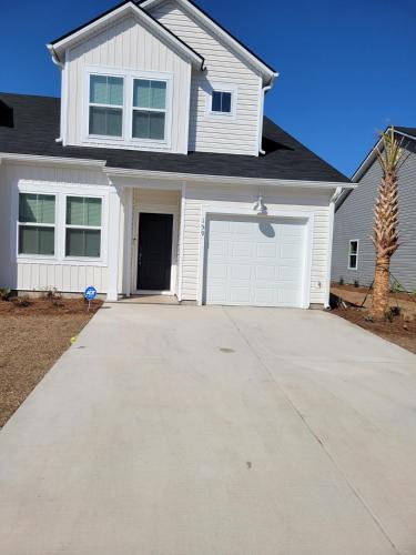 a white house with a driveway and a garage at Coastal Charm 3-bedroom townhome in Myrtle Beach