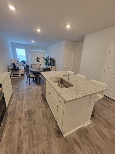 a kitchen with a sink and a living room at Coastal Charm 3-bedroom townhome in Myrtle Beach