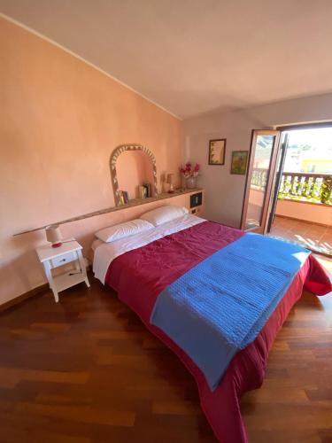 a bedroom with a bed with a red and blue blanket at Zanella House in Quartu SantʼElena