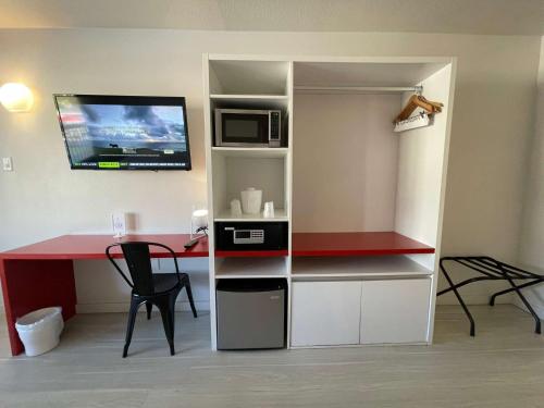 a room with a desk and a microwave and a table at Cozy hotel with Super location near Disney in Kissimmee