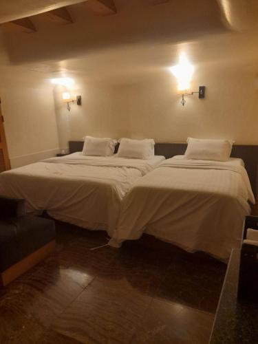 two beds in a room with white sheets and pillows at Yeoksam Molta 1 in Seoul