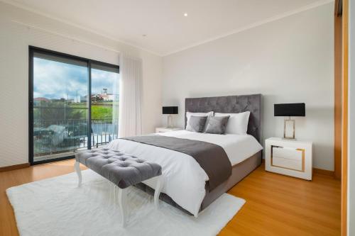 a bedroom with a large bed and a large window at Cerrado da Eira, Vista Mar e Farol in Ponta Garça