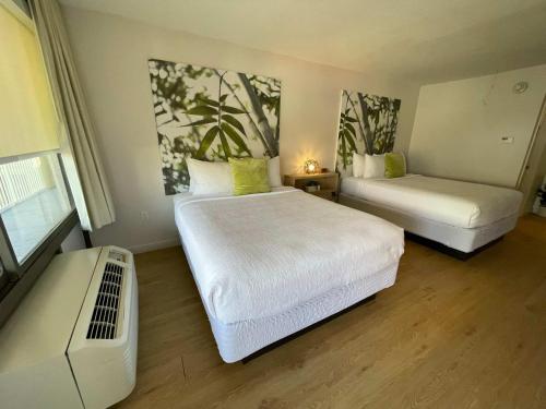 a hotel room with two beds and a couch at Newly renovated room in cozy hotel near Disney 2 in Kissimmee