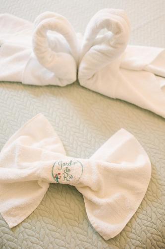 a pair of swan towels on a bed at Jardim do Rio Suítes in Florianópolis