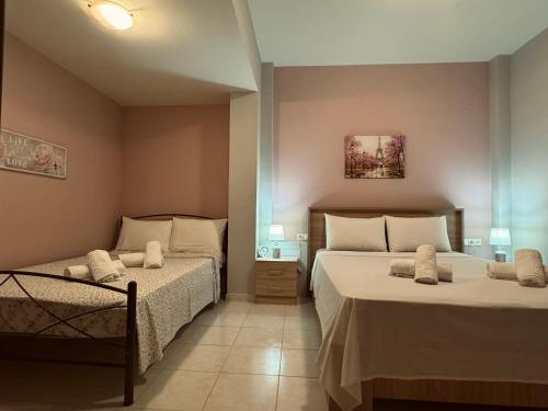 a bedroom with two beds with white pillows at Philoxenia Guest House in Makrirrákhi