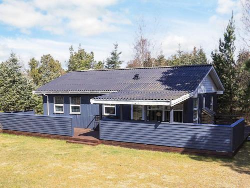 a small blue house with a porch in a yard at 6 person holiday home in Væggerløse-By Traum in Bøtø By