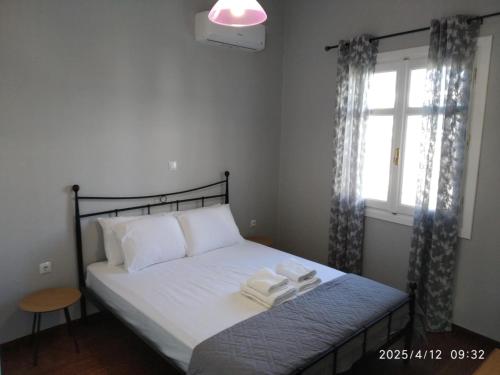 a bedroom with a bed with two towels on it at Oneiro Paralio Astros Nisi in Paralion astros