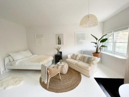 a living room with a bed and a couch at Cozy Coach House in Kitchener