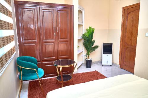 a room with a bed and two chairs and a door at Levels Guest Home in Yaoundé
