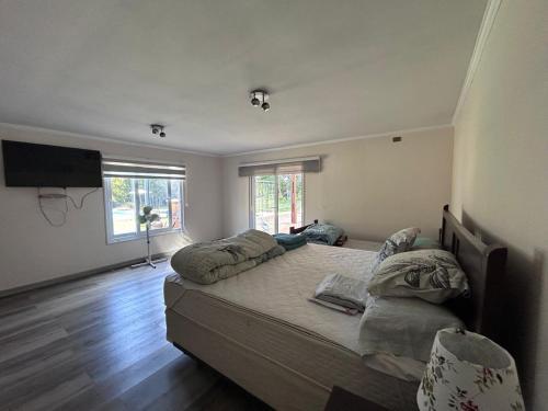 カブルグアにあるcasa amplia, parcela exclusiva, para 14 personasの大きなベッドと薄型テレビのある寝室