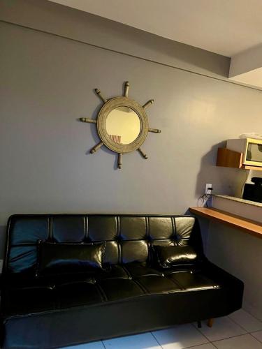 eine schwarze Ledercouch mit einem Spiegel an der Wand in der Unterkunft Golden Dolphin Gran Hotel in Caldas Novas