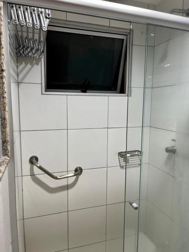 eine Glasdusche mit Fenster und ein Fernseher in der Unterkunft Golden Dolphin Gran Hotel in Caldas Novas