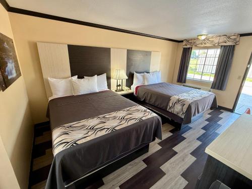 a hotel room with two beds and a window at Regency 7 Motel in Fayetteville