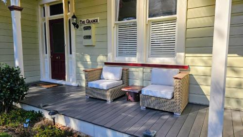 two chairs and a table on the porch of a house at The Grange in Auckland