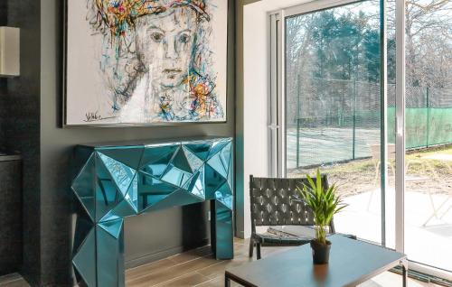 une table et une chaise dans une pièce avec un tableau dans l'établissement Suite Charmilles Avec Piscine, à Gien