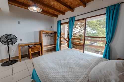 a bedroom with a bed and a window at Hotel Nantu Hostería in Puerto López