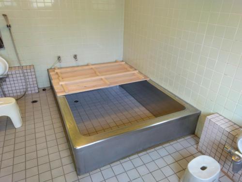 a bathroom with a tub in the middle of a room at Ogawaya Ryokan - Vacation STAY 15998v in Tahara
