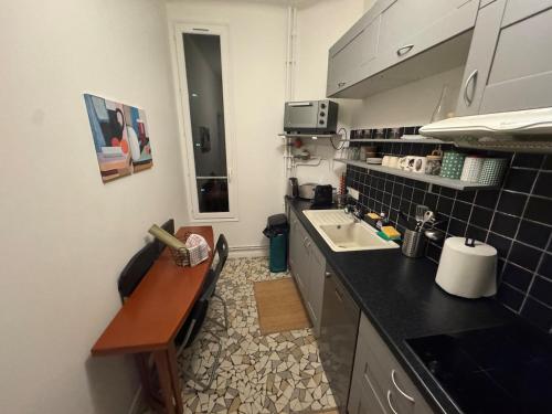 une petite cuisine avec un évier et un comptoir dans l'établissement Studio chic Saint Germain des Pres, à Paris