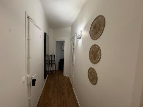 un couloir avec trois plaques sur un mur dans l'établissement Studio chic Saint Germain des Pres, à Paris