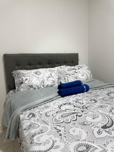 a bed with a blue pillow on top of it at Flat mobiliado in Arapiraca